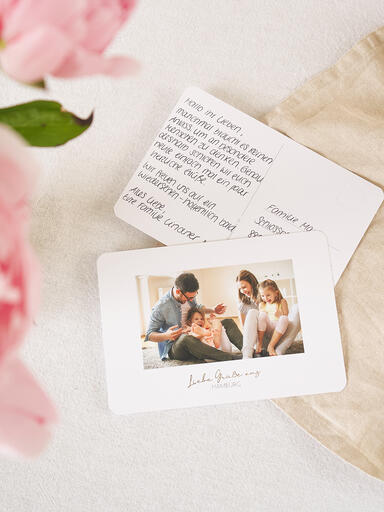 Fotopostkarten mit einem Familienfoto auf der Vorderseite und einem von Hand geschriebenem Text auf der Rückseite