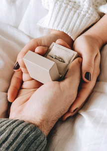 Frau öffnet Umschlag mit Hochzeitseinladung