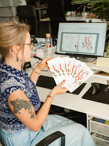 Designerin Carina beim kreieren eines Foto-Tischspiels im 'Boho Moho'-Design